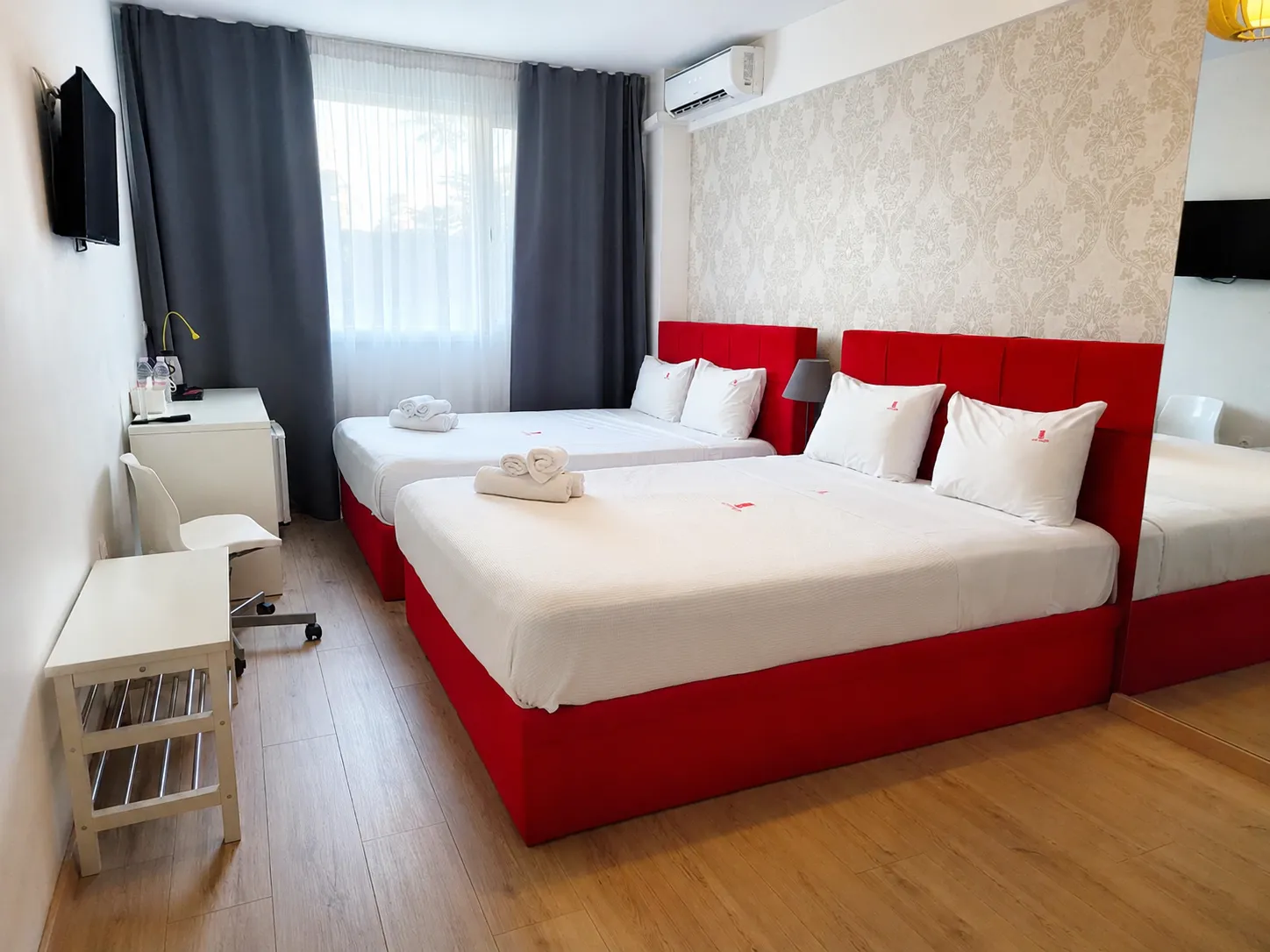 realistic photo of the Family Room of City Plaza Hotel featuring 2 large double beds